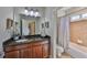 Bathroom featuring granite counters, a large mirror, and a shower with tile walls at 6640 Park Strand Dr, Apollo Beach, FL 33572