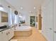 Luxurious bathroom features a soaking tub, dual vanities, tile floors, and a walk-in closet at 6640 Park Strand Dr, Apollo Beach, FL 33572