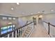 Upstairs hallway with views of the living room below, featuring a staircase and large windows at 6640 Park Strand Dr, Apollo Beach, FL 33572