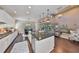 Open-concept living space with island, connecting to the kitchen and dining area with dark granite countertops at 6640 Park Strand Dr, Apollo Beach, FL 33572