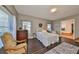 Bright bedroom with hardwood floors, neutral walls, and a view of the ensuite bathroom at 6640 Park Strand Dr, Apollo Beach, FL 33572