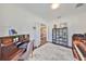 Well-lit home office with a wooden desk, piano, display cabinet, and french doors leading to another room at 6640 Park Strand Dr, Apollo Beach, FL 33572
