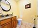 Half bath features a granite countertop, wood vanity, tile flooring, and classic fixtures at 7705 W Four Pines Rd, Plant City, FL 33565