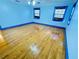 Spacious bedroom with hardwood floors and bright blue trim around the windows and baseboards at 7705 W Four Pines Rd, Plant City, FL 33565