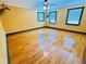 Spacious bedroom with hardwood floors, three bright windows, and deer head decor at 7705 W Four Pines Rd, Plant City, FL 33565