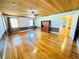 Open-concept living room with wood ceiling, hardwood floors, and wainscoting at 7705 W Four Pines Rd, Plant City, FL 33565