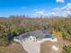 Aerial shot of the property showcasing its impressive solar panel system, screened-in porch, and wooded surroundings at 9911 Mendel Dr, New Port Richey, FL 34654