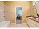 Bright bathroom features tiled floors, a tub/shower combo, and a doorway leading to a vanity area at 9911 Mendel Dr, New Port Richey, FL 34654