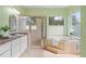 Bright bathroom offers a soaking tub, a glass-enclosed shower, double sink vanity, and neutral tile floors at 9911 Mendel Dr, New Port Richey, FL 34654