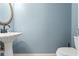 Half bathroom featuring a pedestal sink, toilet and light blue walls at 9911 Mendel Dr, New Port Richey, FL 34654