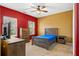 Well-lit bedroom with wood furniture, neutral carpet, two windows and red and gold walls at 9911 Mendel Dr, New Port Richey, FL 34654