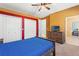 Comfortable bedroom with wood furniture, a ceiling fan, and a doorway leading to another room at 9911 Mendel Dr, New Port Richey, FL 34654