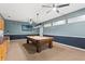 Spacious game room featuring a pool table, television, and dark blue wainscoting at 9911 Mendel Dr, New Port Richey, FL 34654