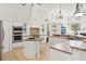 Spacious kitchen with stainless steel appliances, white cabinetry, and light-colored countertops at 9911 Mendel Dr, New Port Richey, FL 34654
