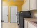 Functional laundry room with side-by-side machines, upper cabinets, and a sink at 9911 Mendel Dr, New Port Richey, FL 34654