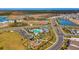 Community aerial view shows pool, playground and many houses with green lawns and ponds around at 12015 Lansing Gln, Parrish, FL 34219