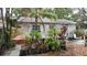 Exterior view of backyard with greenery and partially covered deck and home in need of repairs at 1207 Pine Nw Ave, Largo, FL 33770