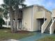 Exterior view of two-story condominium with palm trees, stairs, and a balcony at 121 Loblolly Ct # H, Oldsmar, FL 34677