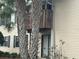 Close up of condominium exterior with sliding glass door, balcony, and palm trees at 121 Loblolly Ct # H, Oldsmar, FL 34677
