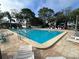 Community swimming pool with lounge chairs on a brick paver deck at 121 Loblolly Ct # H, Oldsmar, FL 34677
