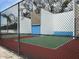 Fenced outdoor racquetball court with colorfully painted walls and playing surface at 121 Loblolly Ct # H, Oldsmar, FL 34677