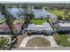 Aerial view showing a home with a circular driveway and manicured lawn near a serene lake at 1230 75Th N Ave, St Petersburg, FL 33702
