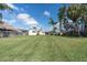 Wide back yard featuring a well-maintained lawn and a charming single-story home at 1230 75Th N Ave, St Petersburg, FL 33702
