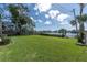 Expansive back yard featuring a large grassy area and partial views of the lake at 1230 75Th N Ave, St Petersburg, FL 33702