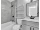 Well-lit bathroom with a shower-tub combo, modern fixtures, and open storage at 1230 75Th N Ave, St Petersburg, FL 33702