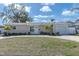 Charming single-story home with a well-manicured front yard, a curved walkway, and an attached single-car garage at 1230 75Th N Ave, St Petersburg, FL 33702