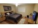 Cozy bedroom with neutral walls, ceiling fan, wooden bed, and a mounted TV at 12413 Oak Cedar Pl # 201, Tampa, FL 33612