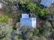 Aerial view showing the house, metal roof, outbuildings, and expansive, wooded lot with mature trees at 12950 Lincoln Rd, Riverview, FL 33578