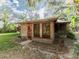 Backyard shows a separate bonus room with a door and three windows, and an exposed beam screened-in porch at 12950 Lincoln Rd, Riverview, FL 33578