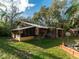 Secluded backyard with green grass, a mature trees, and a screened-in porch, creating a private outdoor space at 12950 Lincoln Rd, Riverview, FL 33578