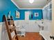 Charming bathroom with white fixtures, wooden accents, and vibrant blue walls at 12950 Lincoln Rd, Riverview, FL 33578