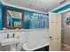 Stylish bathroom featuring a clawfoot tub, pedestal sink, and bright blue walls at 12950 Lincoln Rd, Riverview, FL 33578