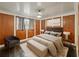 Bedroom features a cozy bed with modern decor, contrasting wood walls, and a large window at 12950 Lincoln Rd, Riverview, FL 33578