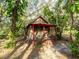 A quaint cabin in the woods is shown on a sunny day at 12950 Lincoln Rd, Riverview, FL 33578