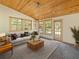 Bright living room with wood ceiling, large windows, and a comfortable seating arrangement at 12950 Lincoln Rd, Riverview, FL 33578