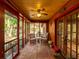 Enclosed porch with tile flooring, ceiling fan, and inviting seating arrangement perfect for relaxing and enjoying the scenery at 12950 Lincoln Rd, Riverview, FL 33578