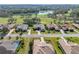 Aerial view of home, mature trees and landscaping, golf course and lake in the background at 13854 Thoroughbred Dr, Dade City, FL 33525