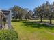 Expansive green backyard with mature trees and a view of the golf course at 13854 Thoroughbred Dr, Dade City, FL 33525