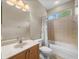 Well-lit bathroom featuring a vanity with a sink, toilet, and a shower/tub combo with tiled surround at 13854 Thoroughbred Dr, Dade City, FL 33525