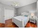 Cozy bedroom featuring hardwood floors, a ceiling fan, and closet doors with a bookcase at 13854 Thoroughbred Dr, Dade City, FL 33525