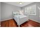 Charming bedroom featuring hardwood floors, a ceiling fan, and natural light from a window with plantation shutters at 13854 Thoroughbred Dr, Dade City, FL 33525