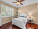 Cozy bedroom features a ceiling fan, window with shutters, and hardwood floors at 13854 Thoroughbred Dr, Dade City, FL 33525