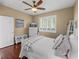 Bedroom featuring a ceiling fan, window with shutters, and hardwood floors at 13854 Thoroughbred Dr, Dade City, FL 33525