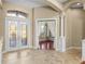 Inviting foyer showcasing decorative glass doors, tiled flooring, and an arched entrance to a cozy living area at 13854 Thoroughbred Dr, Dade City, FL 33525