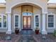 Home's front entryway features double doors with decorative glass and sidelight windows at 13854 Thoroughbred Dr, Dade City, FL 33525