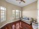 Comfortable living room with hardwood floors, multiple windows with shutters, and a relaxing seating area at 13854 Thoroughbred Dr, Dade City, FL 33525